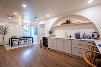 the kitchen and dining room of a house with a table and chairs